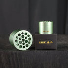 Two Hanataba bouquet twisters in the Matcha Green design. The products are placed on it's black original packaging with Hanataba Original written in gold. The display is in a dark room on a black wooden table.