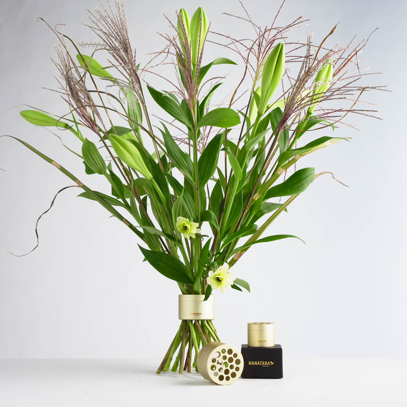 Amazing green and purple bouquet of lilies and grass in a golden hanataba flower twister