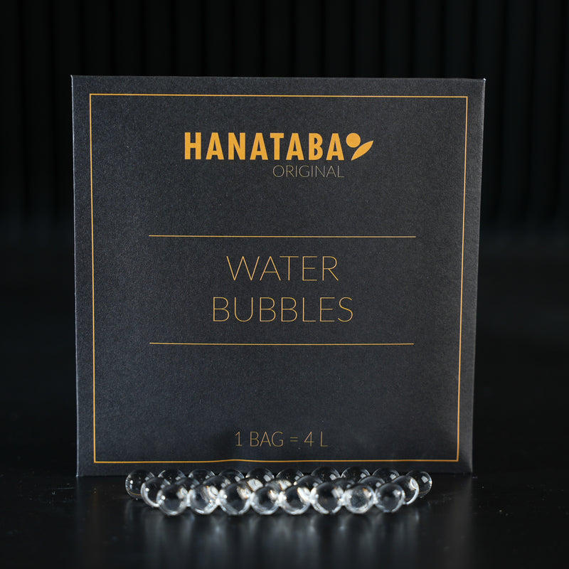 Una sofisticata confezione etichettata "HANATABA Original Water Bubbles" con il testo "1 BAG = 4L", accompagnata da bolle d'acqua trasparenti nella parte anteriore, progettata per valorizzare le composizioni floreali.